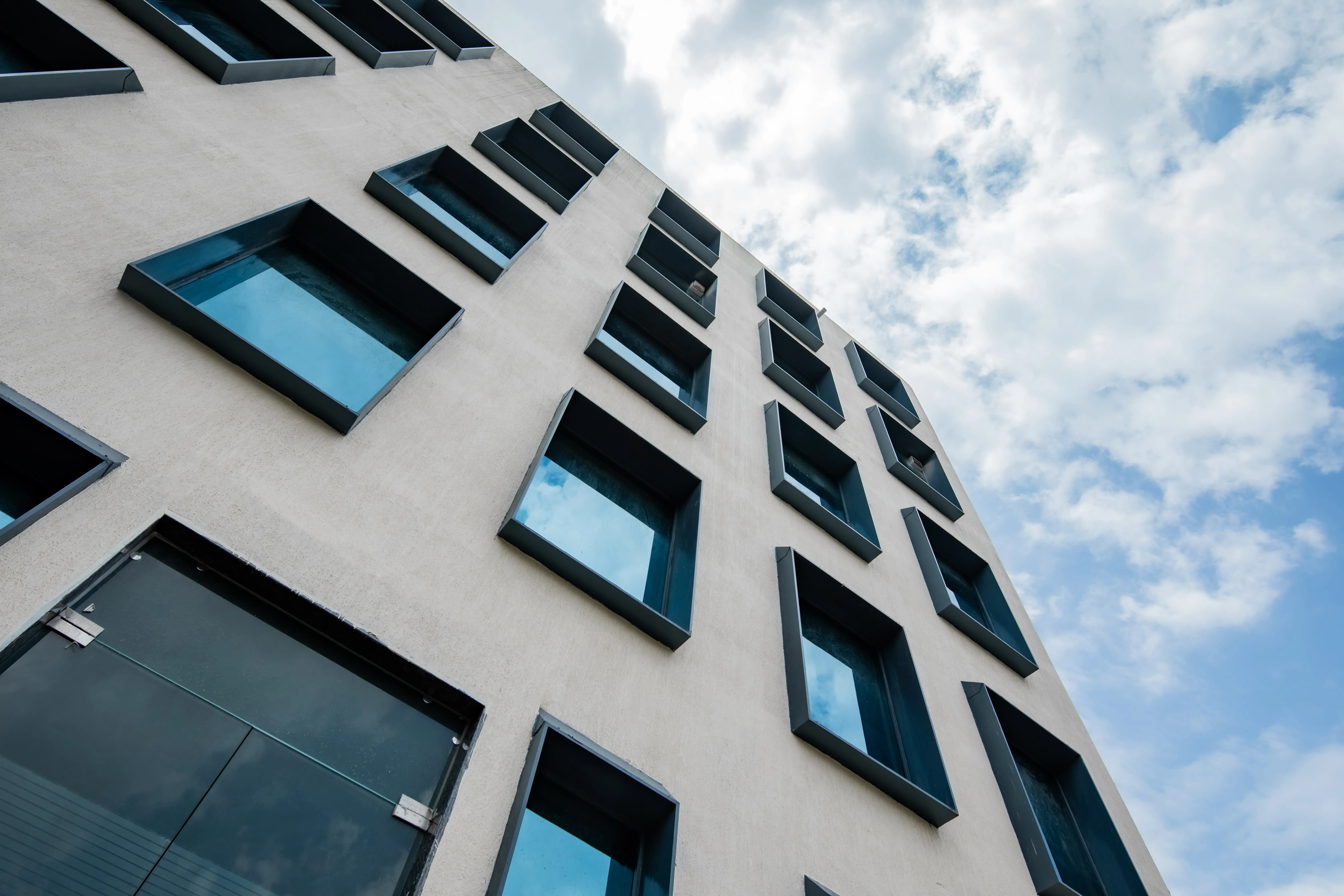 A contemporary hospital facade with deep-set framed windows — considered envelope design for a hot climate.