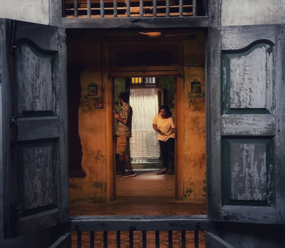 A courtyard window opening in an old house in Ahmedabad, its shutters open onto an ochre interior.
